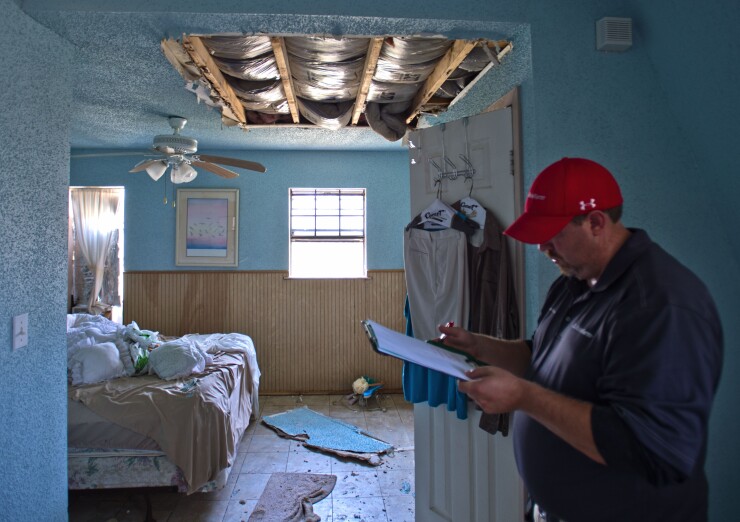 A State Farm catastrophe claims adjuster surveys a home affected by Hurricane Harvey in Rockport, Texas, on Sept. 2, 2017. Hurricane Harvey inflicted damage on 1.7 million homes that could top $11.5 billion in insured losses, according to CoreLogic Inc.